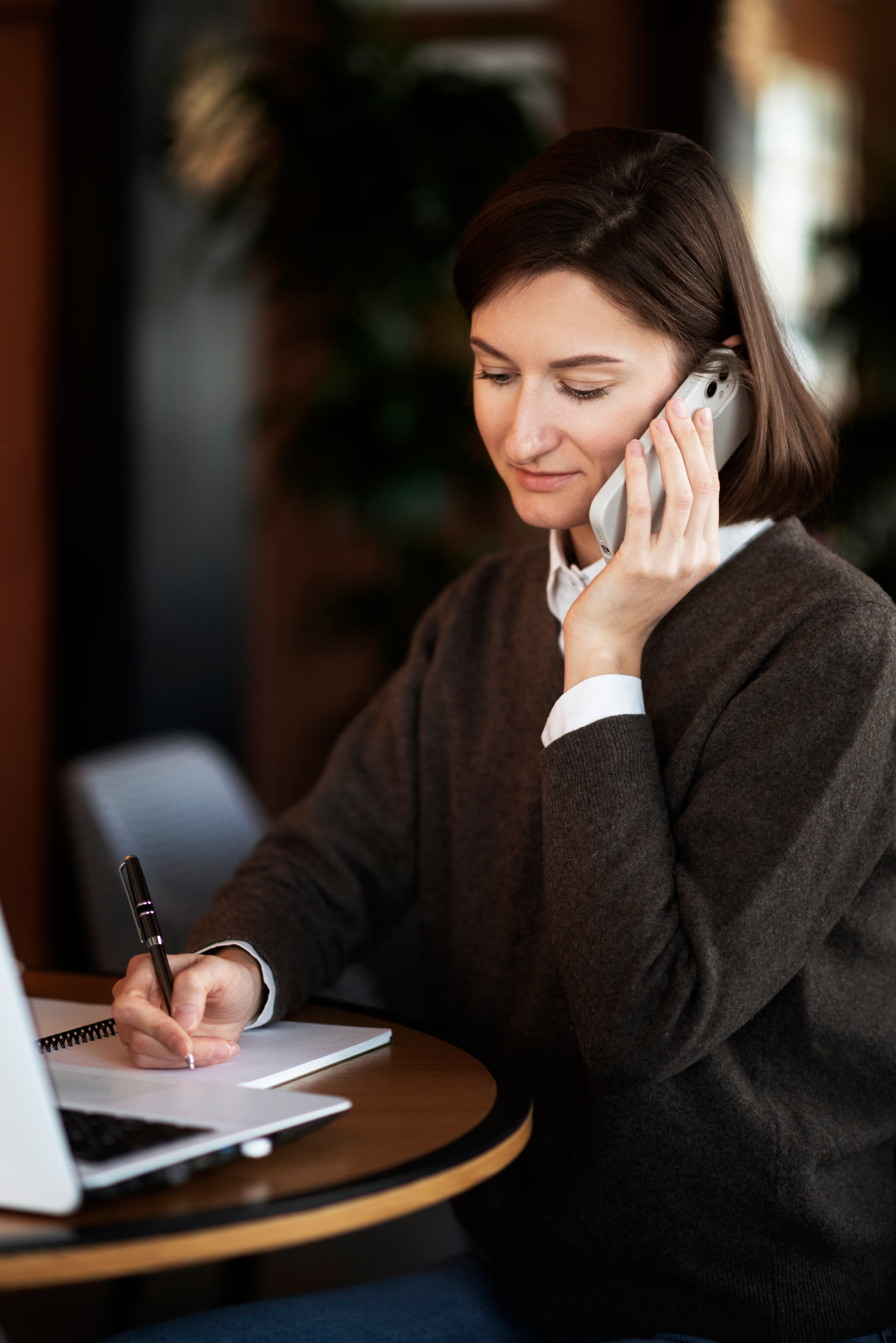 Team member on a call and taking notes, ready to help with your questions.